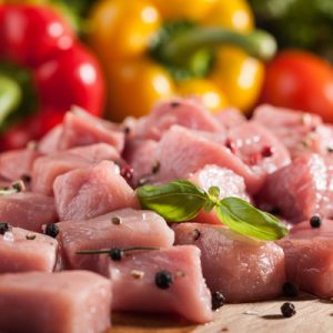 Raw pork  on cutting board and fresh vegetables on wooden table